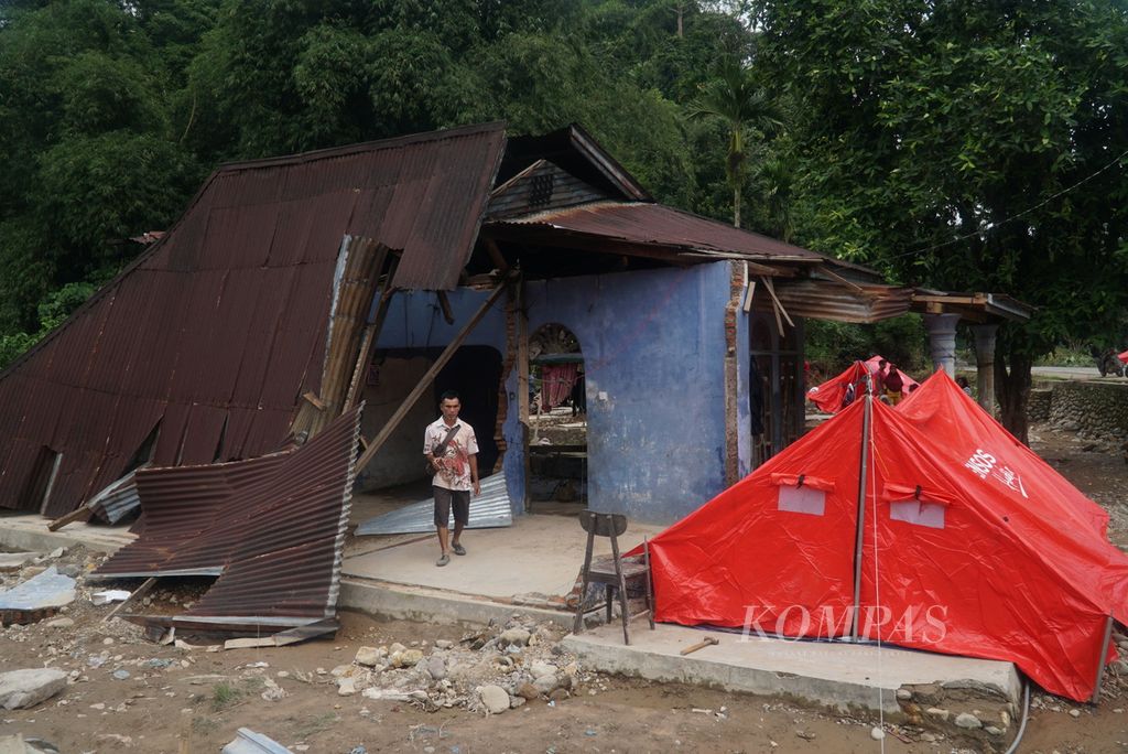 Warga melintas di puing-puing rumah yang hancur akibat banjir bandang di Kampung Ganting, Nagari Ganting Mudiak Selatan Surantih, Kecamatan Sutera, Kabupaten Pesisir Selatan, Sumatera Barat, Selasa (12/3/2024). 