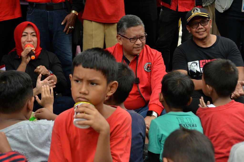Salah satu kader PDI-P (kiri) memberikan sambutan kepada warga dalam acara Makan Bareng 10.000 Warga DKI Jakarta di Jalan Baladewa, Johar Baru, Jakarta Pusat, Minggu (8/1/2023). Acara untuk menyambut HUT ke-50 PDI-P ini membagikan makanan kepada ribuan warga. Acara ini dihadiri Sekretaris Jenderal PDIP Hasto Kristiyanto yang turut menyapa warga. 
