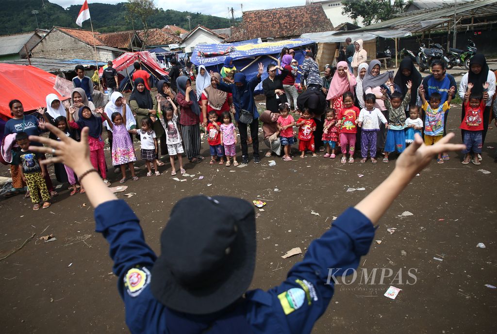 Relawan dari Karang Taruna Cigondewah Kaleh, Bandung bersama TNI Angkatan Laut menghibur anak-anak korban gempa dalam program pemulihan trauma di Desa Pakuon, Kecamatan Sukaresmi, Kabupaten Cianjur, Jawa Barat, Minggu (27/11/2022). Kegiatan seperti ini membantu meringankan beban psikologis anak-anak korban gempa.