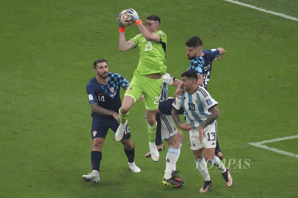 Kiper Argentina Emiliano Martinez mengamankan bola di depan gawang saat menghadapi Kroasia di babak semifinal Piala Dunia 2022 di Stadion Lusail, Qatar, Rabu (14/12/2022) dini hari WIB. Argentina melaju ke final Piala Dunia 2022 setelah mengalahkan Kroasia 3-0. 