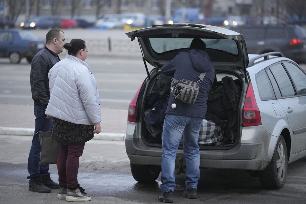 People pack bags into the back of a car in Sievierodonetsk, the Luhansk region, eastern Ukraine, Thursday, Feb. 24, 2022. Russian President Vladimir Putin on Thursday announced a military operation in Ukraine and warned other countries that any attempt to interfere with the Russian action would lead to "consequences you have never seen." 