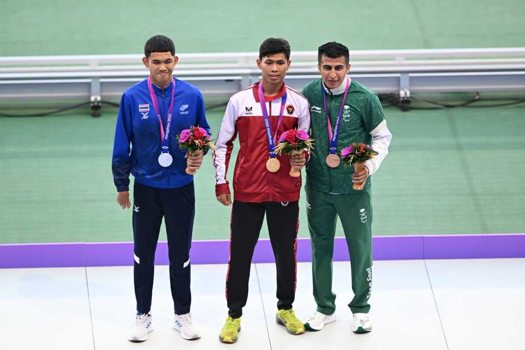 Saptoyogo Purnomo (tengah), atlet atletik paralimpiade nomor lari 400 meter klasifikasi T37 atau keterbatasan koordinasi gerak, termasuk akibat <i>cerebral palsy</i>, meraih medali emas pada hari pertama Asian Para Games 2022 di Huanglong Sport Centre, Senin (23/10/2023). Saptoyogo kembali meraih emas dari nomor 200 meter klasifikasi T37 Asian Para Games Hangzhou, Rabu (25/10/2023).