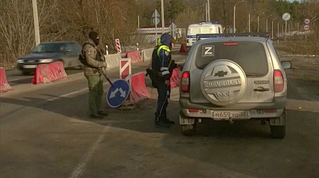 Foto yang diambil dari cuplikan yang disediakan televisi Rusia RU-RTR pada 3 Maret 2023 menunjukkan petugas polisi Rusia memeriksa dokumen pengemudi tak jauh dari perbatasan Rusia-Ukraina di Rusia. Rusia menyebut sekelompok penyabot menyeberang ke wilayahnya dan menyerang desa terdekat. 