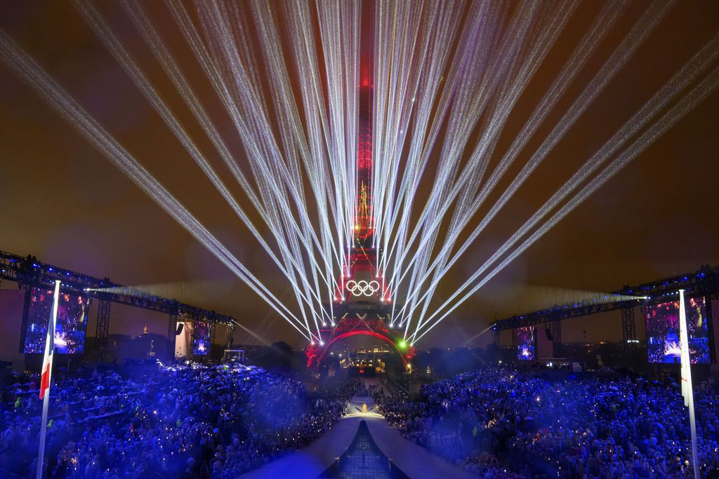 Menara Eiffel bermandi cahaya dilihat dari Trocadero, Paris, Perancis saat pembukaan Olimpiade Paris 2024, Sabtu (27/7/2024) dini hari WIB. 