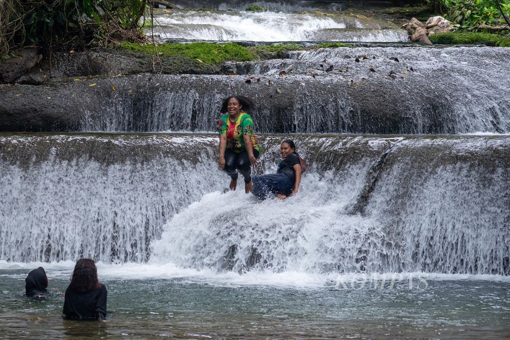 Wisatawan melompat ke sungai di Air Terjun Ubadari di Distrik Kramongga, Kabupaten Fakfak, Papua Barat, Jumat (23/6/2023). Jernihnya air dan asrinya hutan di lokasi itu menjadi daya tarik utama obyek wisata tersebut.