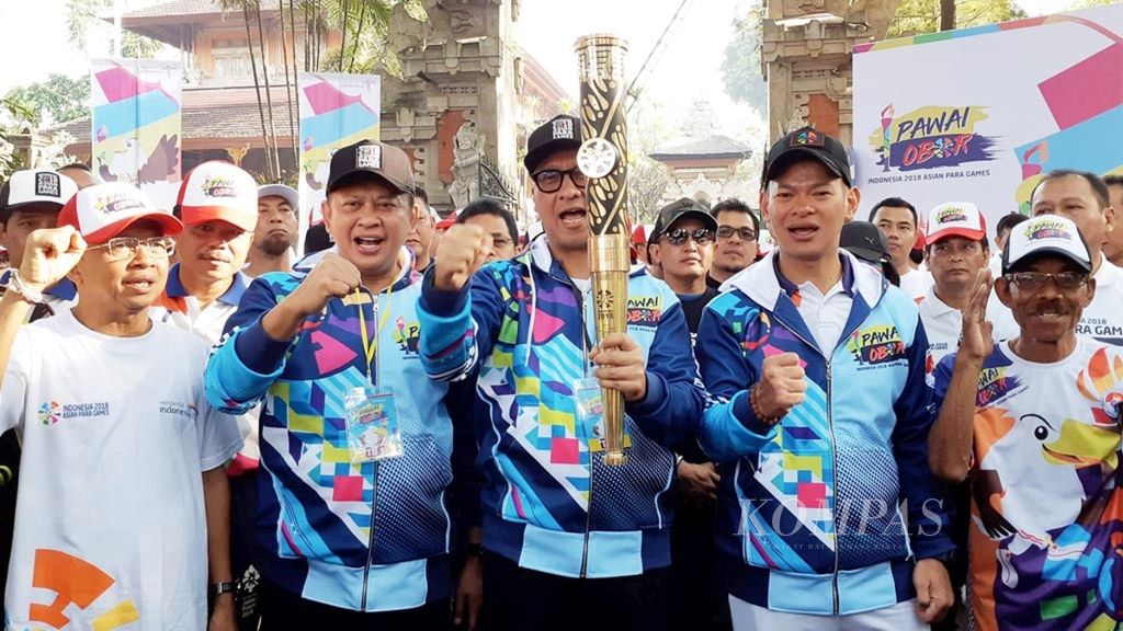 Menteri Sosial Agus Gumiwang Kartasasmita (tengah) membawa obor Asian Para Games 2018 sebelum pawai obor Asian Para Games 2018 di Bali dimulai dari Gedung Jayasabha, kediaman Gubernur Bali, di Denpasar, Minggu (16/9/2018). 