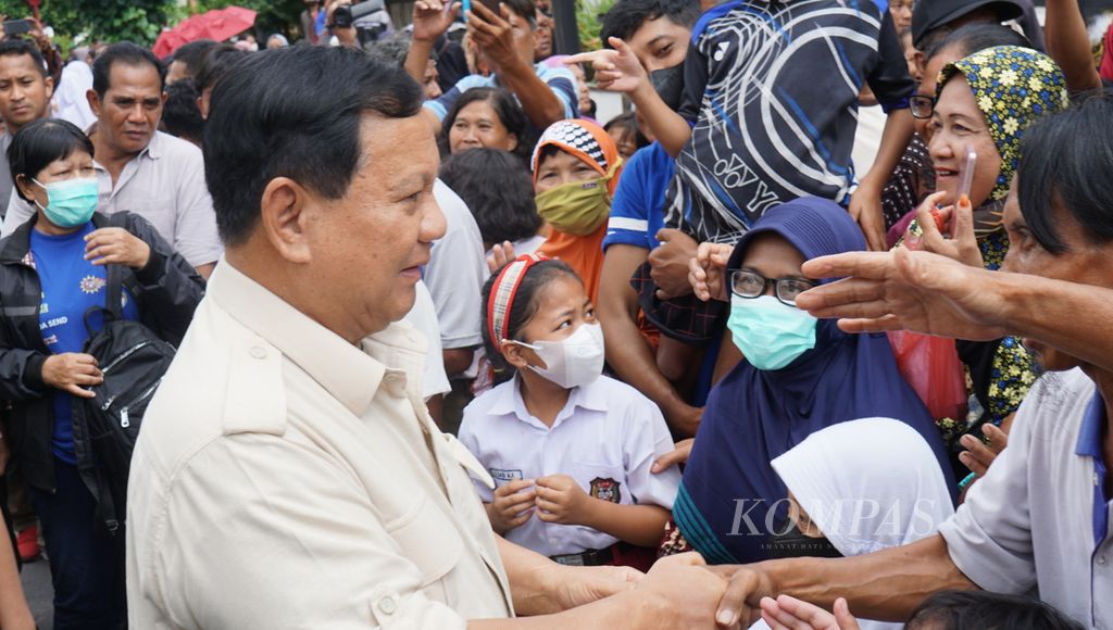 Menteri Pertahanan Prabowo Subianto bersalaman dengan warga sewaktu melaksanakan kunjungan kerja di Kota Surakarta, Jawa Tengah, Selasa (24/1/2023). Dalam kesempatan itu ia membagikan kendaraan dinas bagi babinsa dan bahan kebutuhan pokok kepada sejumlah warga.