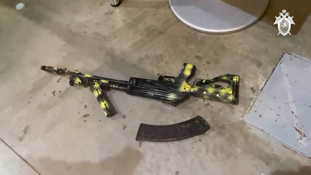 Sebuah senapan serbu Kalashnikov tergeletak di tanah, Sabtu (23/3/2024), saat penyidik ​​dari Komite Investigasi Rusia melakukan reka adegan setelah serangan teroris di Crocus City Hall di pinggiran barat Moskwa, Rusia. 