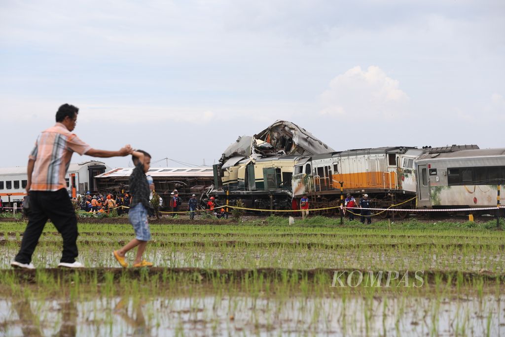 Warga menonton proses penangangan tabrakan antara Kereta Api Turangga tujuan Surabaya Gubeng-Bandung dan Commuterline Bandung Raya di Km 181+700 petak jalan antara Stasiun Haurpugur dan Stasiun Cicalengka, Jumat (5/1/2024).