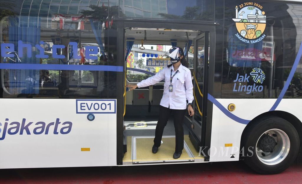 Awak bus listrik Transjakarta mengenakan masker dan pelindung wajah saat uji coba bus listrik, Senin (6/7/2020). 