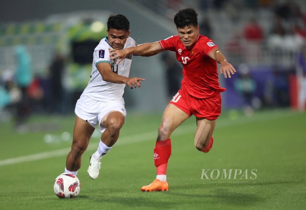 Kapten tim Indonesia, Asnawi Mangkualam (kiri), berebut bola dengan pemain Vietnam, Pham Tuan Hai, pada pertandingan Grup D Piala Asia 2023 di Stadion Abdullah bin Khalifa, Doha, Qatar, Jumat (19/1/2024). 