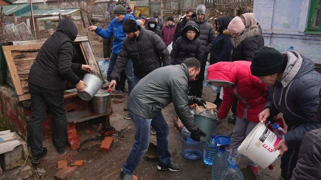 Warga megantre mengambil air di sumur di pinggiran Mariupol, Ukraina, Rabu (9/3/2022).