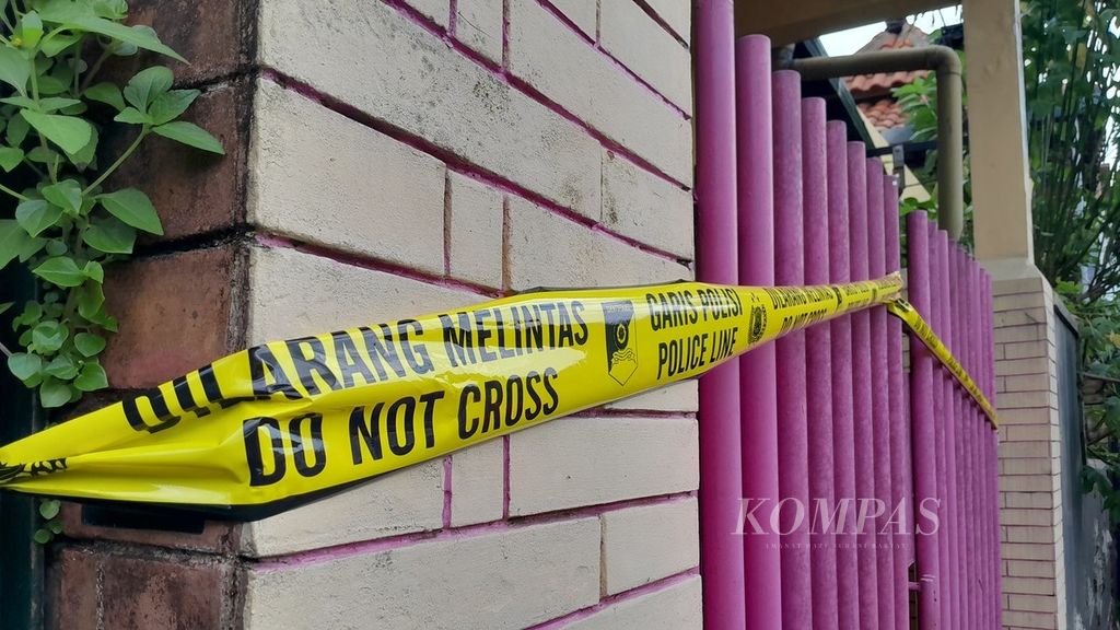 Garis polisi membentang di pagar di lokasi pembunuhan disertai mutilasi oleh suami terhadap istri di Kelurahan Bunulrejo, Kecamatan Blimbing, Kota Malang, Jawa Timur, Minggu (31/12/2023). 