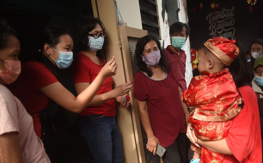 Warga bersiap membagikan angpau saat Imlek di Pecinan Tambak Bayan, Kota Surabaya, Selasa (1/2/2022). 