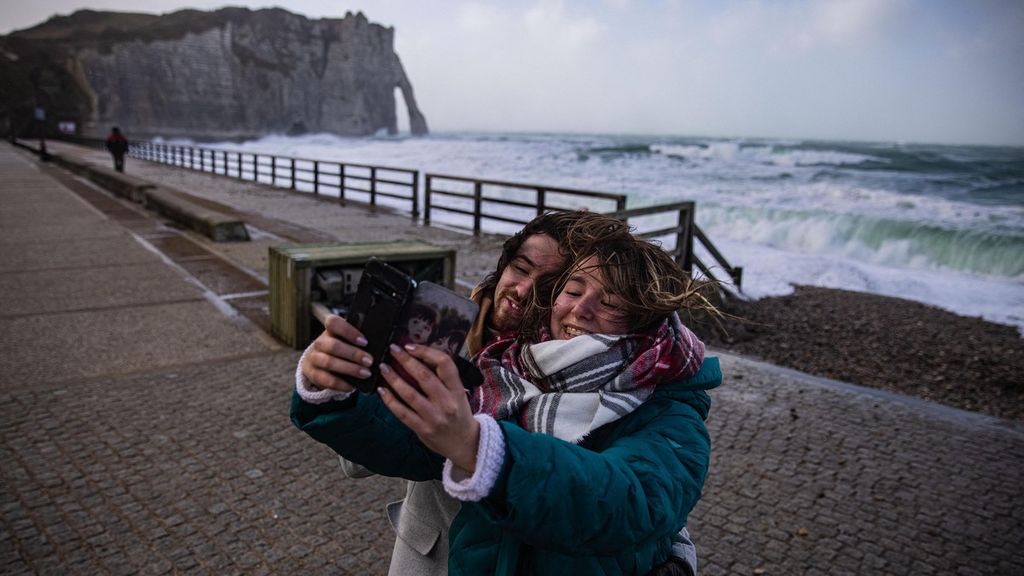 Sepasang kekasih berfoto <i>selfie </i>ketika ombak tinggi menghantam pantai Etretat, Normandia, Prancis barat, pada 18 Februari 2022, saat Badai Eunice menghantam pantai Normandia. Dalam menjalin relasi romantis, kadang muncul kecemburuan terhadap pasangan.