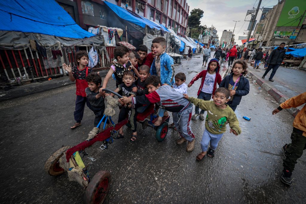 Anak-anak pengungsi bermain di jalan tak jauh dari tenda-tenda tempat tinggal sementara mereka pada hari pertama Idul Fitri di Rafah, Jalur Gaza, pada 10 April 2024. 