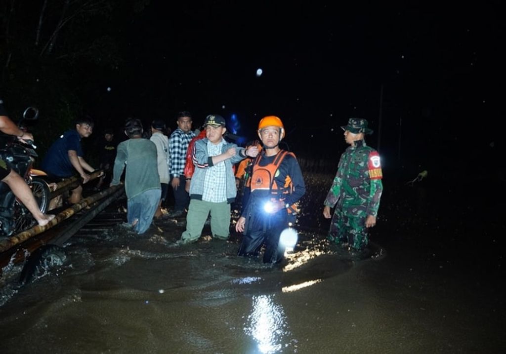 Penjabat Bupati Barito Selatan Deddy Winarwan (tengah dengan topi) memantau banjir yang melanda  jalan Trans-Kalimantan yang menghubungkan Kalteng dengan Kalimantan Timur, Senin (22/1/2024).