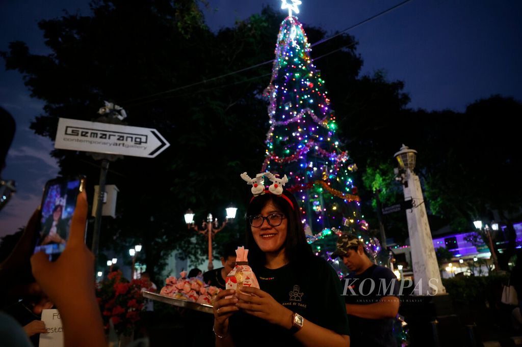 Visitors take photos with Christmas gifts distributed in Kota Lama, Semarang City, Central Java, on Saturday (23/12/2023). Christmas joy colors several corners of Semarang City, including in churches, shopping centers, and public spaces.