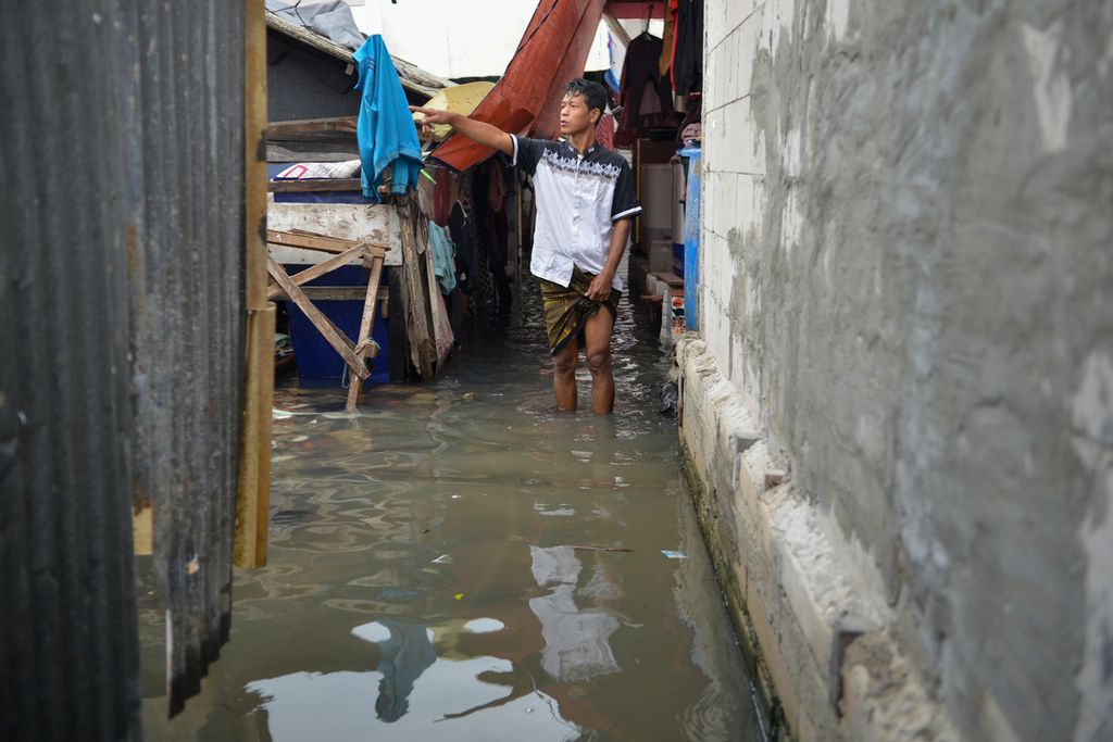Warga menunjukkan tempat air laut yang masuk ke dalam permukiman warga di Blok Empang, Penjaringan, Jakarta Utara, Senin (26/12/2022). 