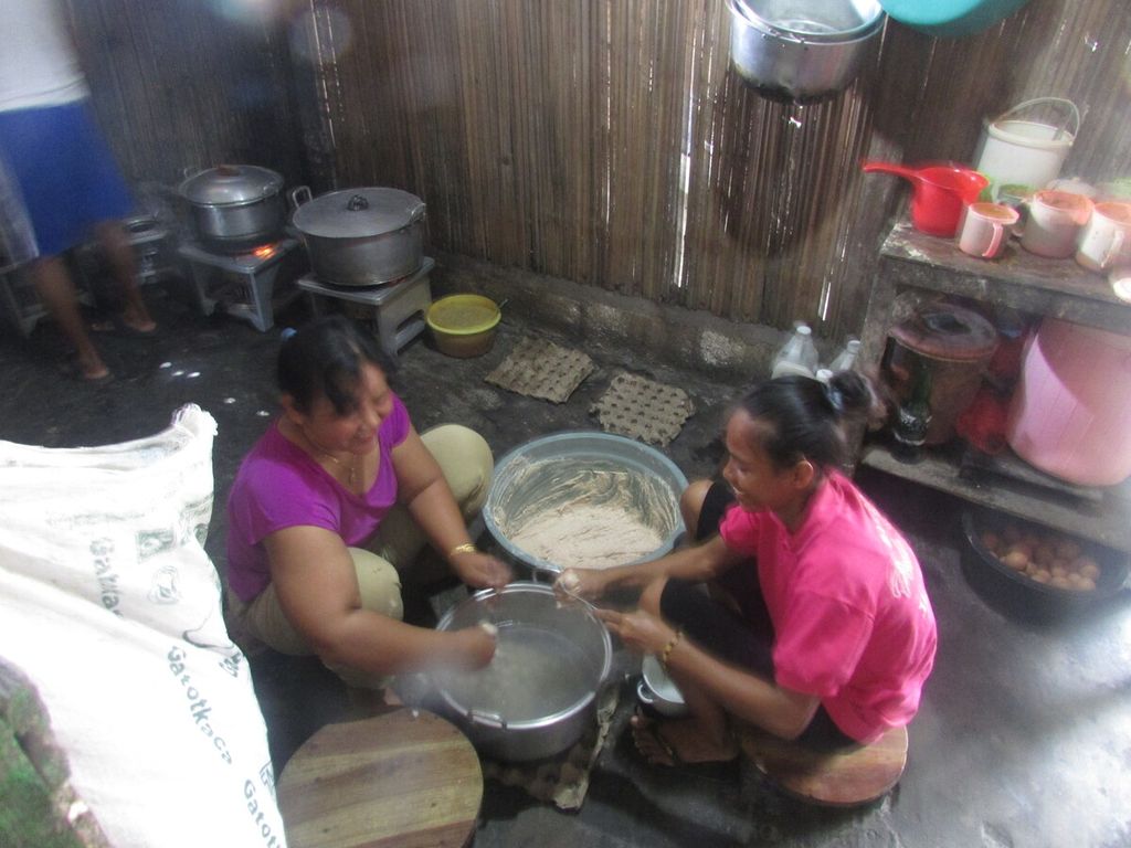Ny Sumarni Nyaman (kiri, berbaju ungu) bersama seorang karyawan meracik bakwan untuk dijual.