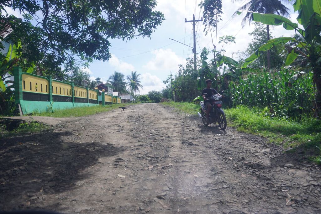 Pengendara motor melintasi jalan yang rusak parah di Ujungmanik, Kecamatan Kawunganten, Kabupaten Cilacap, Jawa Tengah, Sabtu (15/4/2023).