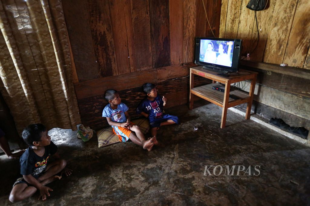 Anak-anak menonton televisi di salah satu rumah warga di Kampung Lale, Desa Wewo, Kecamatan Satar Mese, Kabupaten Manggarai, Nusa Tenggara Timur, Selasa (5/10/2021). Listrik di desa tersebbut menyala sejak November 2011 bersamaan dengan beroperasinya PLTP Ulumbu.