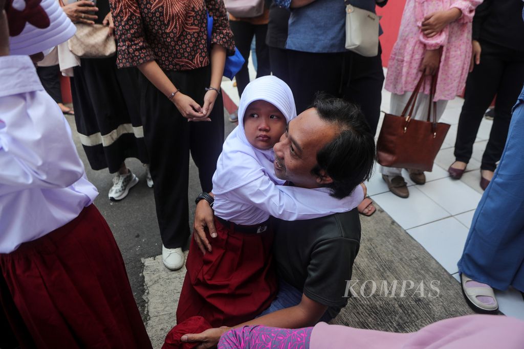 Seorang siswa memeluk orangtuanya sembari menangis pada hari pertama sekolah di SDN 1 Depok Jaya, Kota Depok, Jawa Barat, Senin (17/7/2023). 