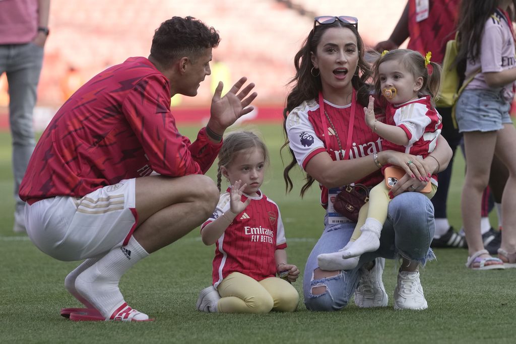 Gelandang Arsenal, Granit Xhaka (kiri), bersama istri dan kedua putrinya merayakan akhir liga inggris usai laga pekan terakhir Liga Inggris antara Arsenal dan Wolverhampton Wanderers di Stadion Emirates, London, Minggu (28/5/2023).