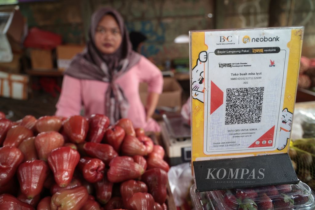 Iyut memanfaatkan kode respons cepat standar Indonesia atau QRIS untuk sistem pembayaran di lapak buahnya di kawasan Muncul, Tangerang Selatan, Banten, Minggu (10/9/2023). Berdasarkan data Bank Indonesia, sampai dengan Juni 2023, jumlah <i>merchant</i> QRIS telah mencapai angka 26,7 juta dengan total jumlah pengguna QRIS sebanyak 37 juta. Jumlah tersebut mencapai 82 persen dari total target pengguna 45 juta pada tahun 2023.