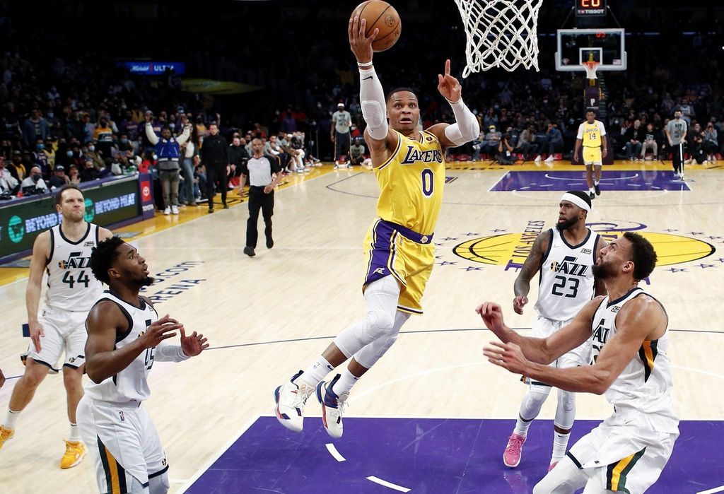Pemain Los Angeles Lakers Russell Westbrook (tengah) melompat untuk melakukan dunk ke ring Utah Jazz pada paruh kedua laga NBA di Arena Crypto.com, Los Angeles, Senin (17/1/2022).