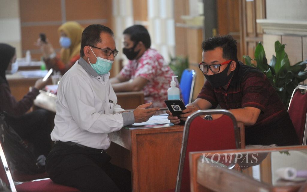 Orang tua siswa mendengarkan arahan dari petugas terkait pendaftaran sekolah di Posko Pengaduaan PPDB di Kantor Dinas Pendidikan Provinsi Jawa Timur, Surabaya, Rabu (24/6/2020).