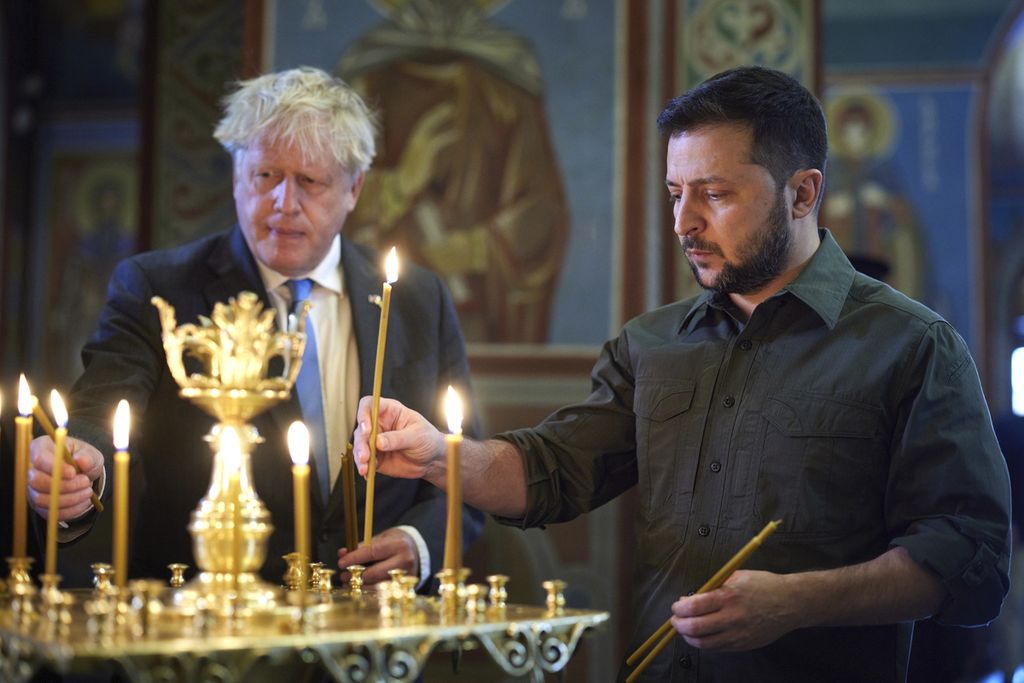 Presiden Ukraina Volodymyr Zelenskyy (kanan) dan Perdana Menteri Inggris Boris Johnson menyalakan lilin-lilin saat keduanya mengunjungi Katedral Mikhailovsky Zlatoverkhy (Katedral Berkubah Emas Santo Michael) di Kyiv, Ukraina, Jumat (17/6/2022). 