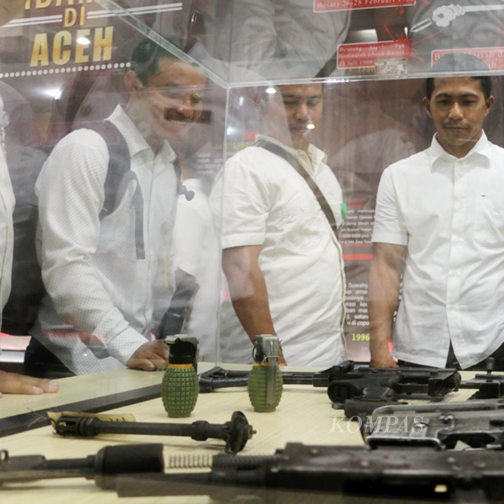 Pengunjung mengamati potongan senjata dan alat peledak bekas konflik yang dipamerkan di ruang kenangan perdamaian di kantor Badan Kebangsaan dan Politik Aceh, Februari 2017.