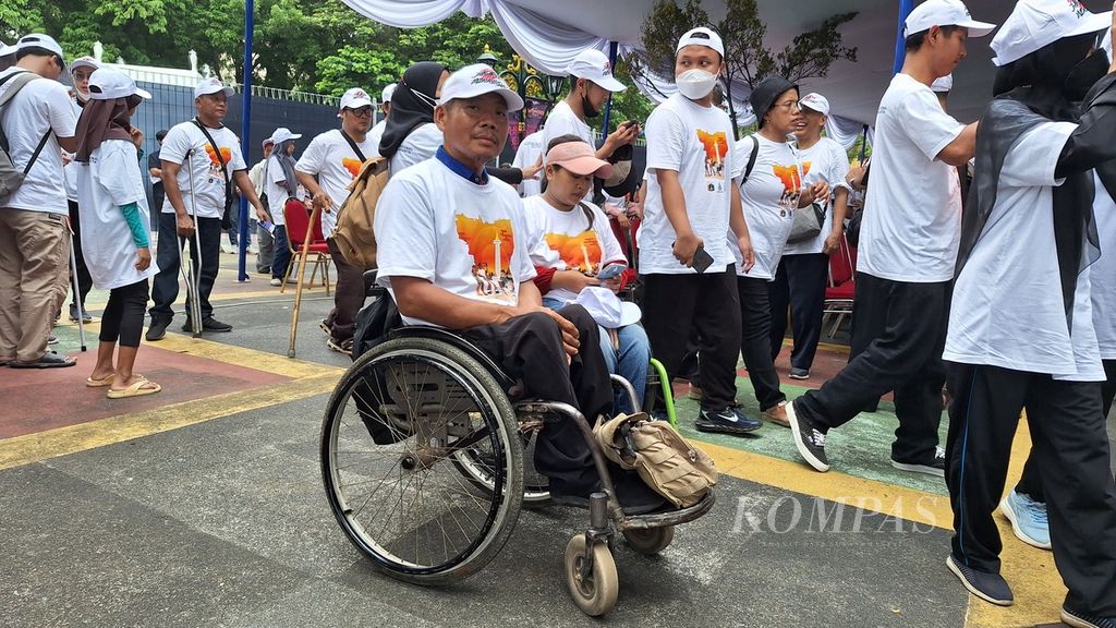 Mang Udin (45) bersama penyandang disabilitas lainnya di Dufan, Ancol Taman Impian, Jakarta Utara, Kamis (7/12/2023).