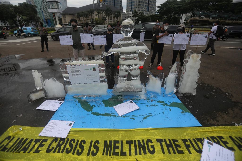 Para aktivis Greenpeace menggelar aksi pengantaran 1.000 kartu pos rakyat kepada presiden di kawasan Tugu Patung Kuda, Jakarta, Rabu (10/11/2021). Kartu pos tersebut berisi pesan agar pemerintah benar-benar melihat dampak buruk perubahan iklim terhadap tempat tinggal dan ekosistem.