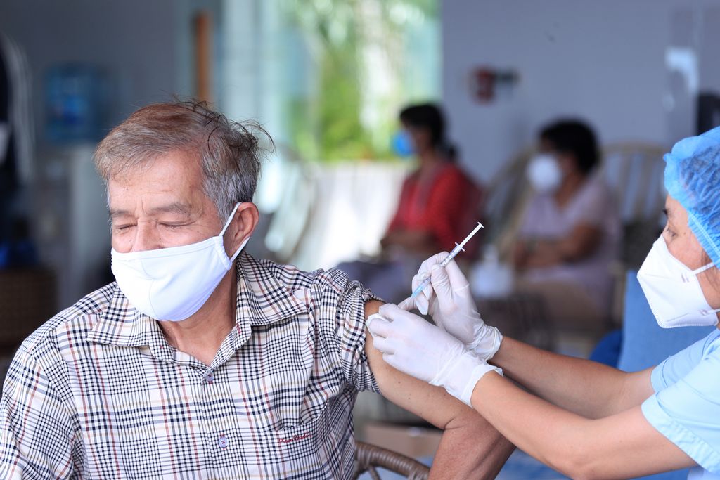 Seorang laki-laki paruh baya mendapatkan suntikan vaksin Covid-19 buatan Moderna di Vung Tau, Vietnam, 13 September 2021. Pascapenanganan Covid-19 yang terkendali selama beberapa tahun terakhir, Vietnam diguncang turbulensi politik setelah dua wakil perdana menteri diberhentikan dari jabatannya. Presiden Nguyen Xuan Phuc, Selasa (17/1/2023), juga mundur dari jabatannya. 