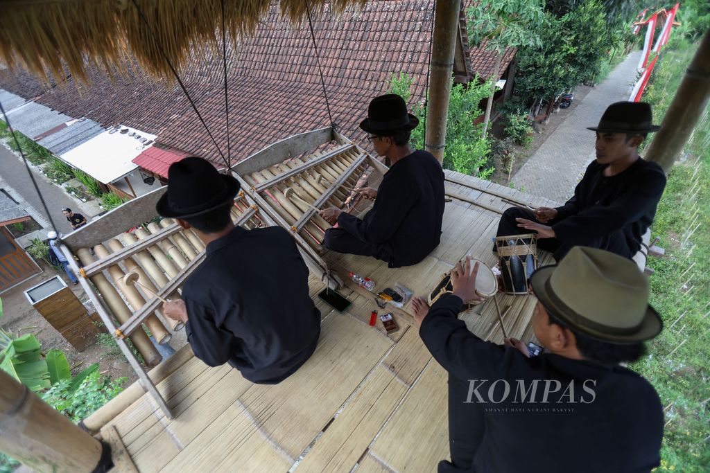 Warga Desa Kemiren bermain alat musik angklung paglak dari atas pagalak atau saung di acara Festival Kemiren 2023 di Desa Kemiren, Kabupaten Banyuwangi, Jawa Timur, Jumat (17/11/2023). 
