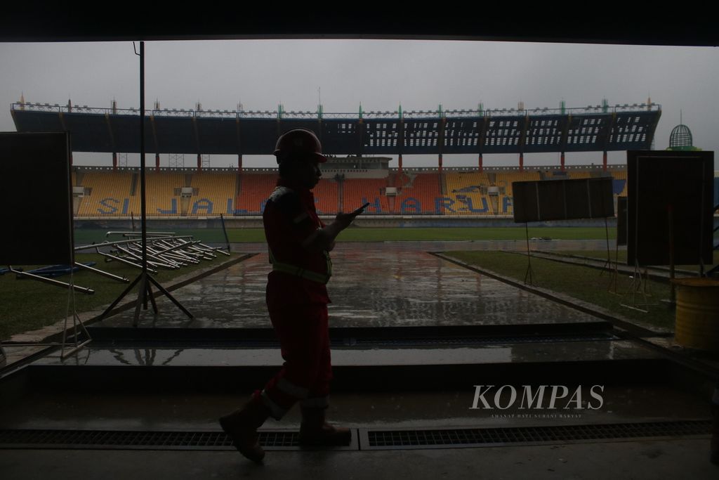 Pekerja melintasi area Stadion Si Jalak Harupat, Kecamatan Soreang, Kabupaten Bandung, Jawa Barat, Senin (20/3/2023). Stadion ini masuk dalam daftar calon lokasi pertandingan Piala Dunia FIFA U-20 di Indonesia.