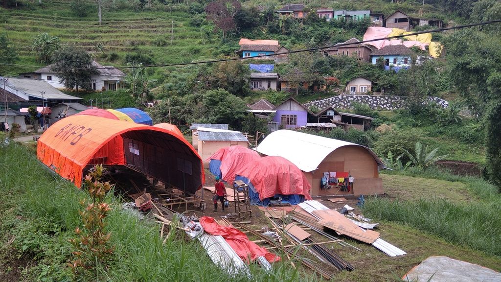 Aktivitas pembangunan tenda pengungsian di Dusun Brau, Desa Gunungsari, Kota Batu, Jawa Timur, masih berlangsung, Minggu (14/3/2021). Ada 16 keluarga terdampak tanah bergerak di tempat ini dan Pemerintah Kota Batu tengah menyiapkan lahan relokasi.