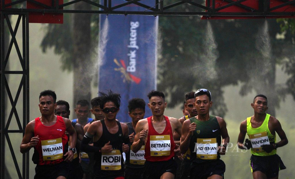 Para pelari putra melintasi gerbang penyemprot air pada Borobudur Marathon 2020 di Taman Wisata Candi Borobudur, Kabupaten Magelang, Jawa Tengah, Minggu (15/11/2020).
