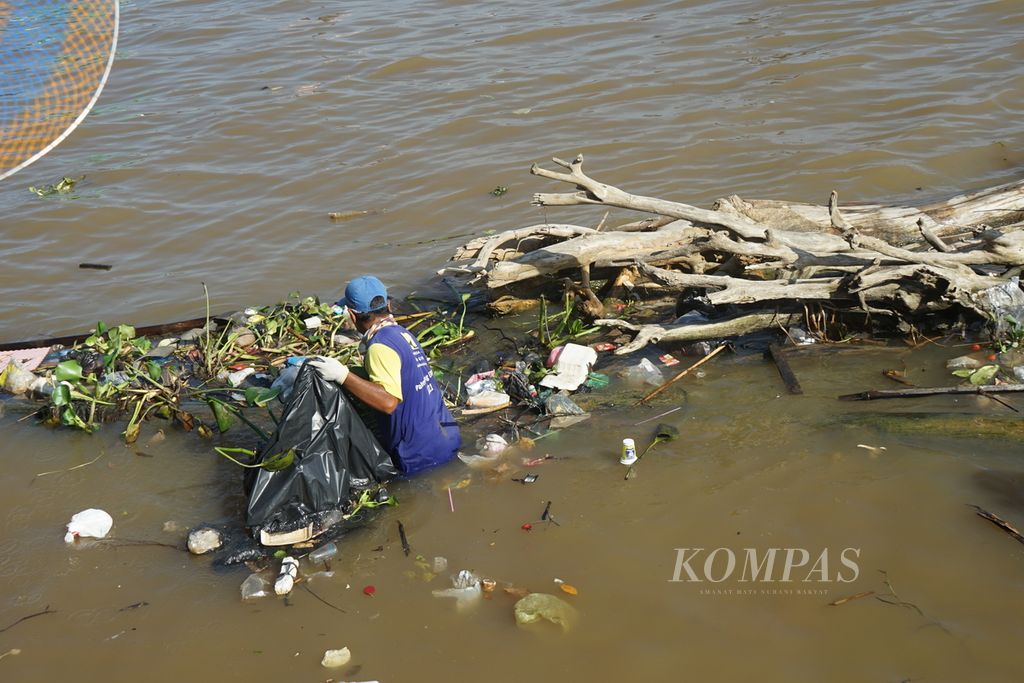 Seorang petugas membersihkan tepian Sungai Musi dari sampah, Sabtu (10/6/2023). Berdasarkan kajian dari Pemkot Palembang, potensi sampah dari sungai di Kota Palembang mencapai 90 ton yang didominasi limbah rumah tangga.