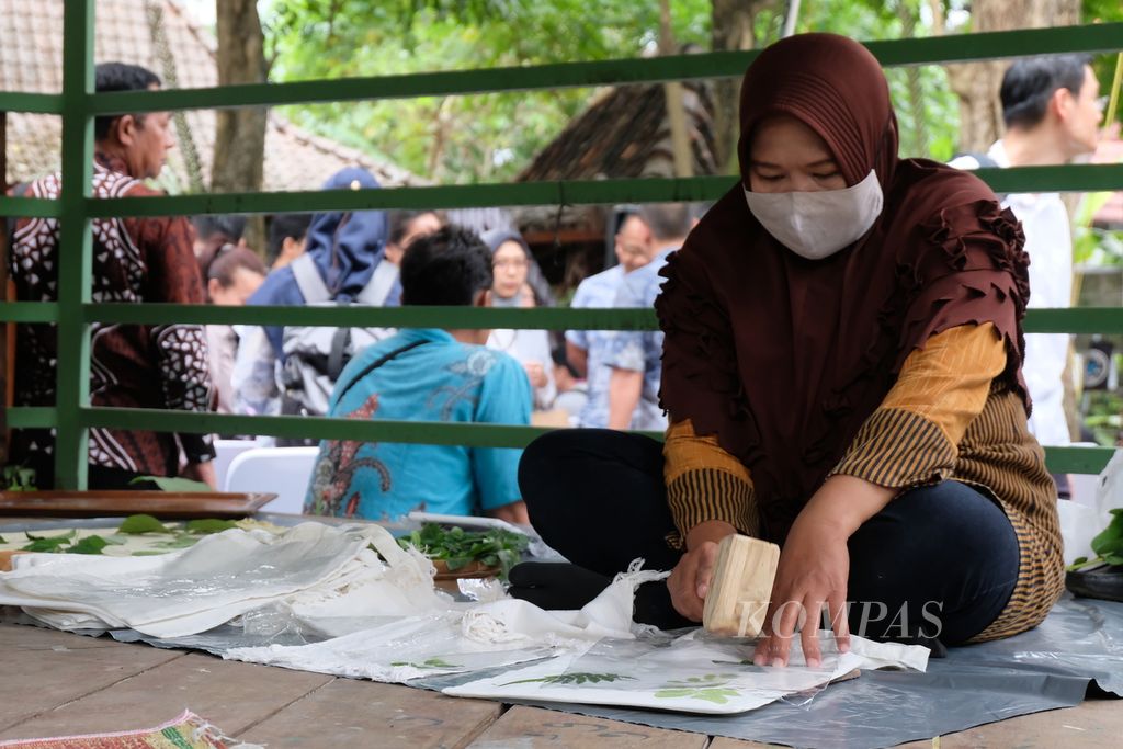 Seorang perempuan membuat motif daun di selembar kain dengan teknik "ecoprint" di Desa Sinduharjo, Kecamatan Ngaglik, Kabupaten Sleman, DI Yogyakarta, Rabu (5/7/2023). Kain "ecoprint" merupakan salah satu komoditas yang dijual.