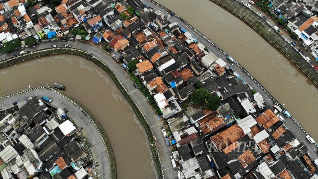 Hujan membasahi hunian di sekitar jalan inspeksi di sisi turap pembatas Kali Ciliwung yang membelah Kelurahan Kampung Melayu, Jakarta Timur, dan Bukit Duri, Jakarta Selatan, Senin (22/1/2019). 