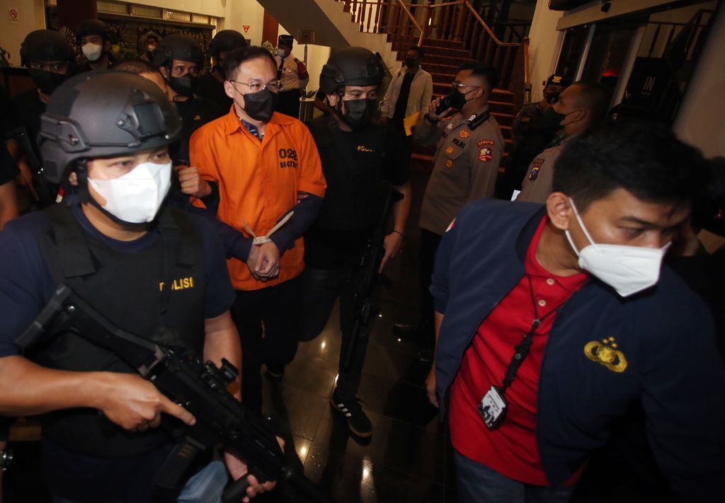 Petugas kepolisian membawa tersangka bandar besar judi online Apin Bak Kim alias Apin BK setibanya dari Malaysia di Bandara Soekarno Hatta, Tangerang, Banten, Jumat (14/10/2022). 