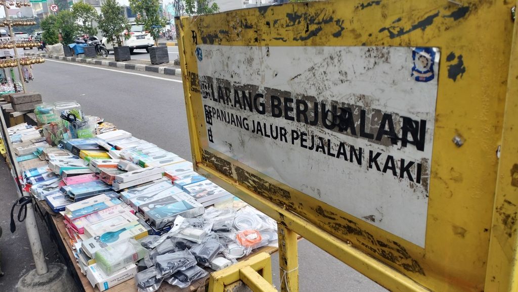 Papan larangan berjualan yang terpasang di pembatas jalan antara jalan raya dan khusus pejalan kaki di turunan jalan layang Pasar Pagi Asemka, Taman Sari, Jakarta Barat, Rabu (19/10/2022).