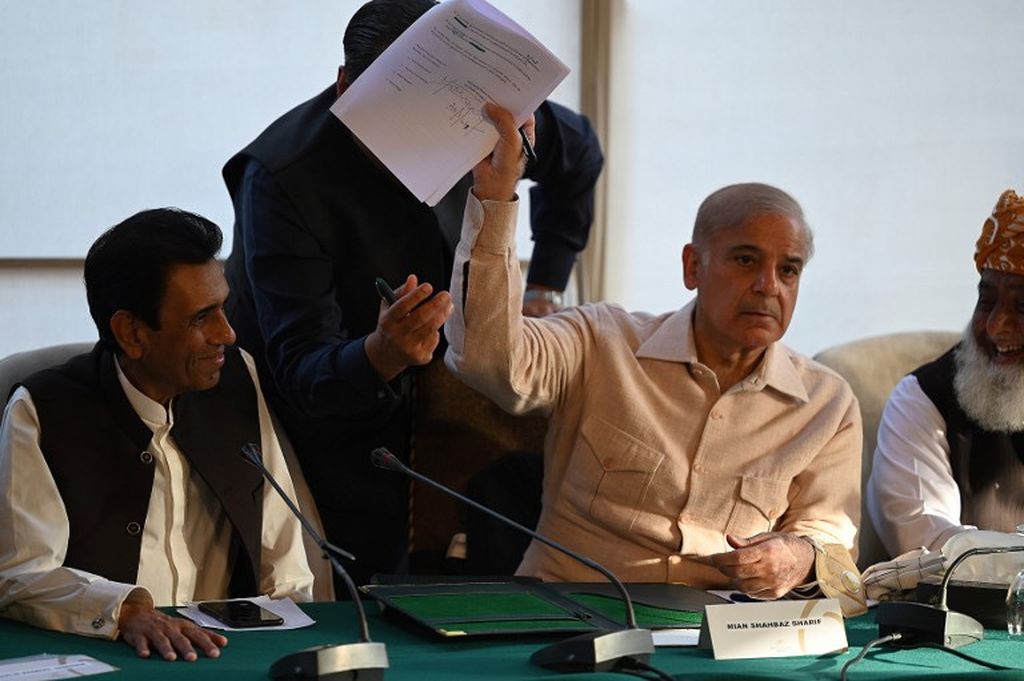 Pemimpin oposisi Pakistan Shahbaz Sharif (ke-2 dari kanan) memperlihatkan dokumen kesepakatan dengan pemimpin Gerakan Muttahida Qaumi (MQM-P), Khalid Maqbool Siddiqui (kiri) selama konferensi pers di Islamabad pada 30 Maret 2022. MQM-P membelot dari koalisi pemerintah dan mendukung oposisi.