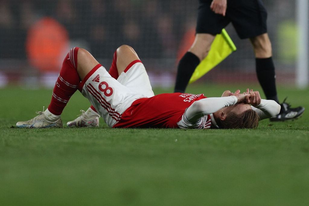Kapten Arsenal, Martin Odegaard, terbaring menutup wajahnya seusai Arsenal ditahan imbang Southampton, 3-3, pada laga Liga Inggris di Stadion Emirates, London, Sabtu (22/4/2023) dini hari WIB.  