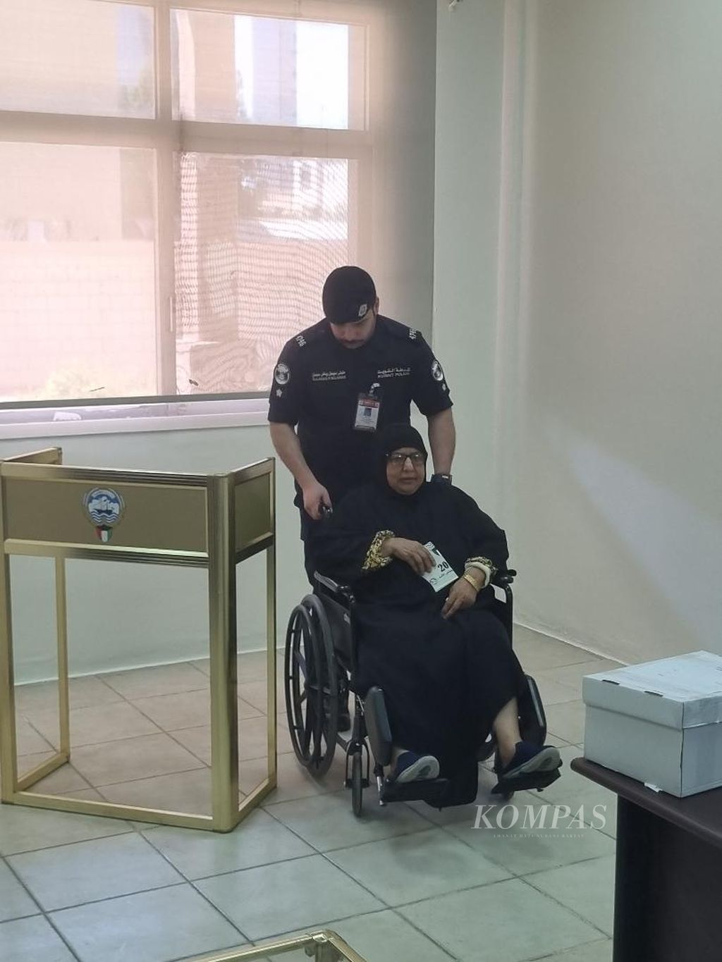 Petugas membantu seorang perempuan untuk menggunakan suara dalam pemilu Kuwait di Kuwait City, Kuwait, Kamis (4/4/2024). 