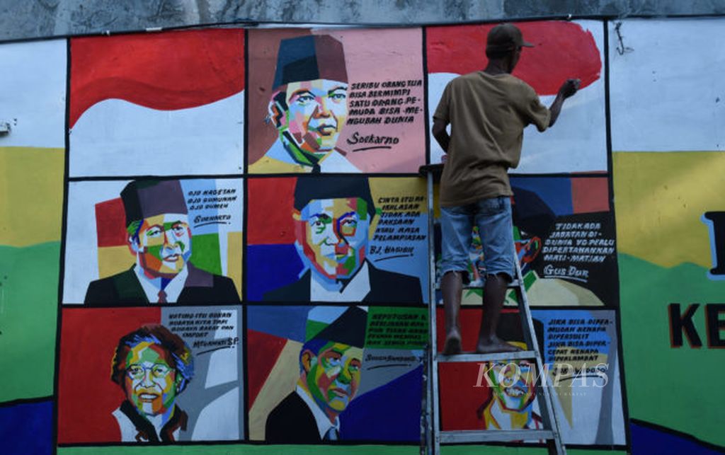 Warga Keputran, Suparlan (57) menghiasi dinding kampungnya dengan gambar-gambar Presiden RI di Surabaya, Jumat (3/8/2018). Selain memeriahkan HUT Ke 73 Kemerdekaan RI, gambar tersebut juga untuk mengingatkan kepada masyarakat untuk tetap damai menjelang PIlpres 2019.