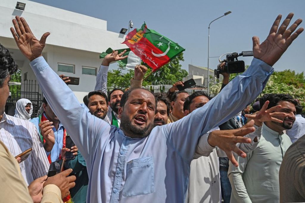 Para pendukung partai berkuasa, Pakistan Tehreek-e-Insaf (PTI), yang dipimpin Perdana Menteri Imran Khan meneriakkan slogan-slogan di luar gedung parlemen di Islamabad, 3 April 2022. 